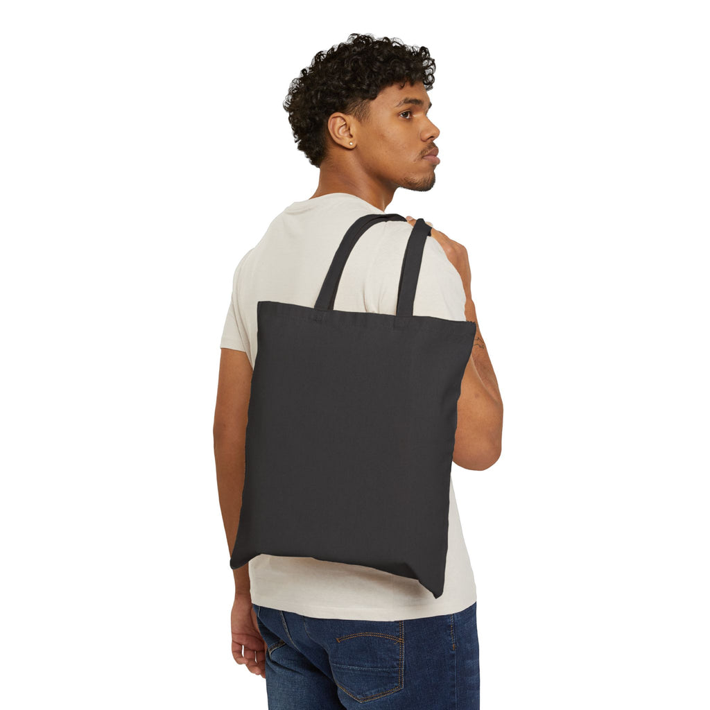 Back view of model carrying Coven x Coven tote bag – black canvas tote with Coven x Coven logo facing away, alternative streetwear accessory