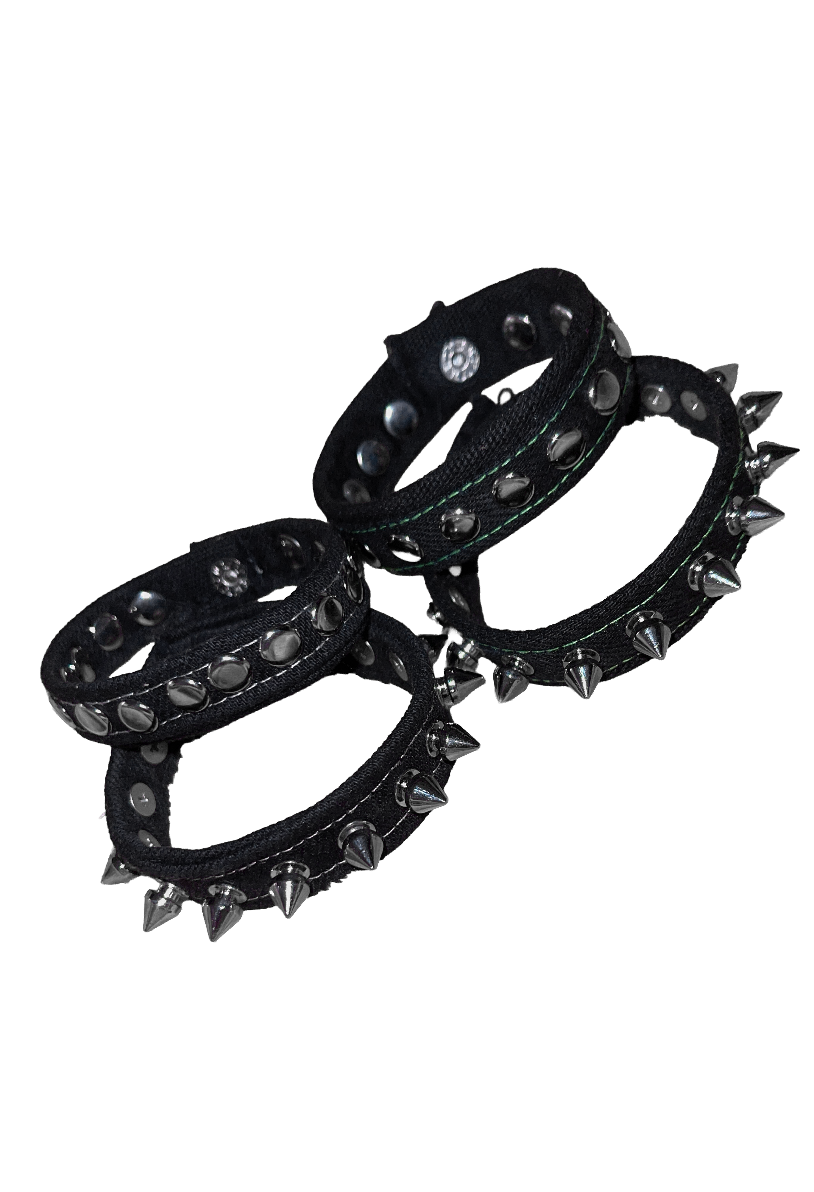 Three black studded Denim cuffs with silver-toned spikes and metal rivets, arranged on a plain white background.