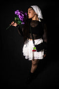Person holding purple flowers against a black background