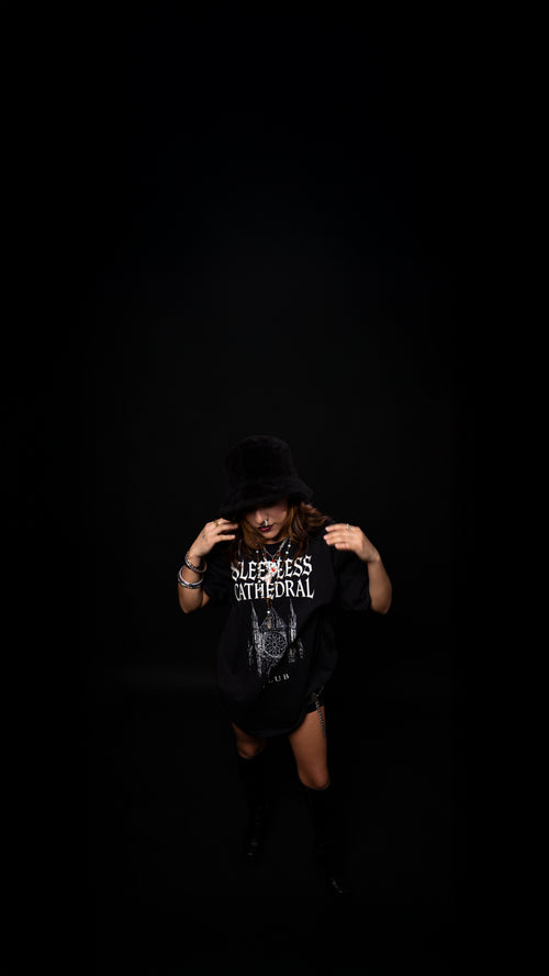 Person wearing a black t-shirt with text on a dark background